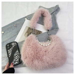 Dettaglio della borsa in peluche rosa con elegante catena decorativa di perle bianche