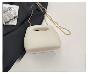 Mini acrylic crossbody bag in cream white compared to a smartphone for scale