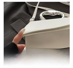 Close-up of precision stitching and silver metal handle on minimalist white leather bag