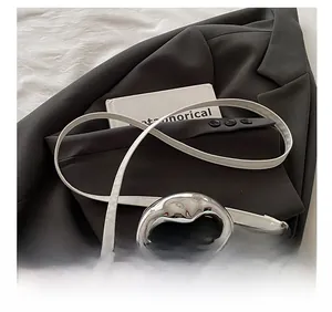 Detail of adjustable strap and liquid silver handle on a white leather shoulder bag