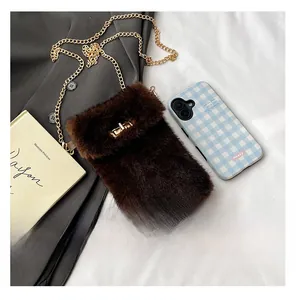 Detail of dark brown faux fur crossbody bag featuring golden chain and twist lock clasp