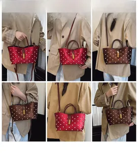 Vista dettagliata della borsa tote a cuore con accenti di perle e rivetti