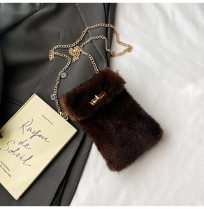 Close-up of deep brown faux fur phone bag featuring golden metal chain and twist lock