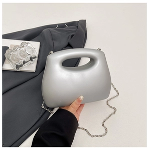 Silver minimalist acrylic box bag with sleek curved handle and metallic chain strap