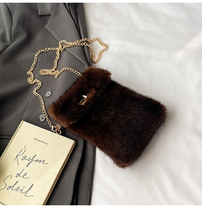 Detail of plush brown shoulder bag with golden twist lock and elegant chain strap