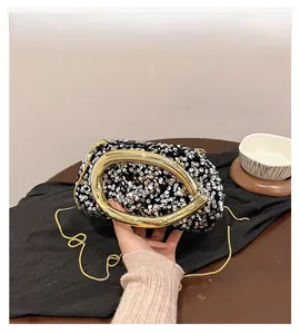 Détail de la pochette de soirée à paillettes argentées avec poignée anneau en métal doré