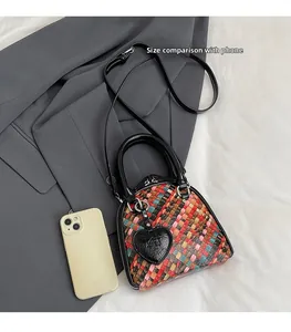 Comparaison de taille détaillée du sac tressé à côté d'un smartphone blanc