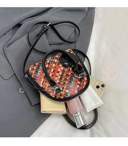 Détail du sac bandoulière tissé montrant l'intérieur spacieux et la texture tressée colorée