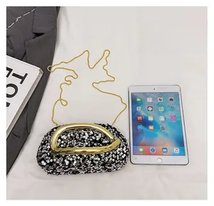 Comparaison de taille entre le sac de soirée à paillettes et un iPad sur tissu blanc