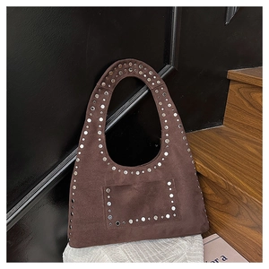 Detail of vintage brown suede hobo bag featuring decorative silver metal studs