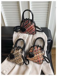 Détail de trois sacs à main tressés multicolores posés sur un canapé en cuir