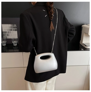 Detailed view of silver metallic acrylic box bag featuring elegant metal chain strap
