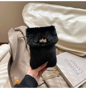 Detail of black faux fur mini bag featuring a gold turn-lock and elegant chain strap
