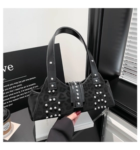 Detail of black leopard print underarm bag with silver rivets and buckle closure