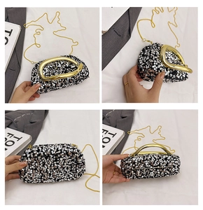 Détail des paillettes noires et argentées et de la poignée dorée de la pochette de soirée