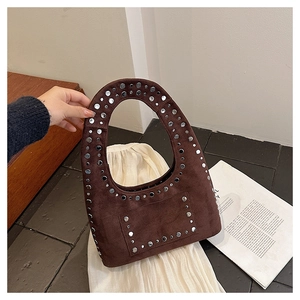 Detail of bohemian dark brown suede hobo bag featuring silver rivet trim and handle