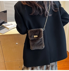 Close-up of plush brown crossbody bag with gold metal chain strap and twist lock detail