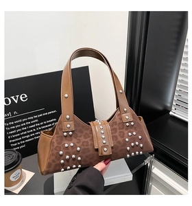 Close-up of leopard print handbag with silver studs and brown leather handle