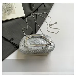 Détail de la pochette à paillettes argentées avec poignée en métal et chaîne de sac