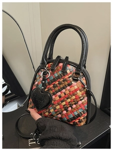 Détail du tissage coloré du sac dôme mini avec breloque cœur noire et anses élégantes