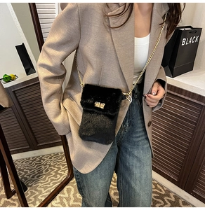 Detail of black faux fur crossbody bag featuring gold chain strap and metal lock closure