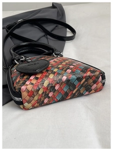 Détail d'un sac à main en cuir tissé coloré avec patchwork et breloque en forme de cœur