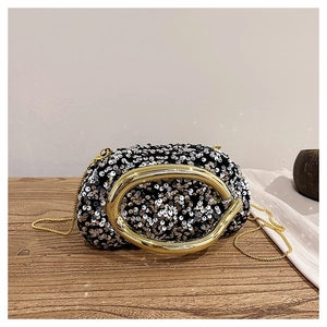 Détail de la pochette de soirée à paillettes avec poignée en métal doré sur bois