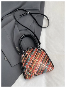 Détail de la texture en cuir tressé multicolore d'un sac à main coquillage et boucles argent