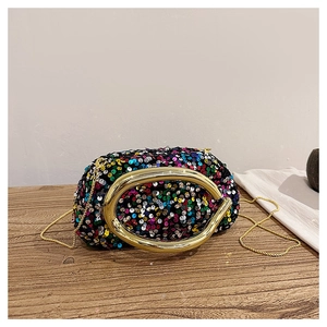 Détail des paillettes colorées et de la poignée en métal doré d'un sac de soirée luxe