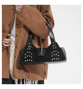 Close-up of leopard print underarm bag with silver studs and polished leather straps