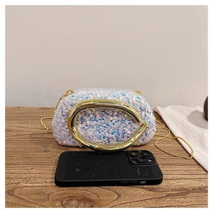 Détail de pochette de soirée à paillettes avec poignée en métal doré et chaîne