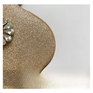 Macro shot of sparkling champagne glitter fabric with teardrop rhinestone floral pattern