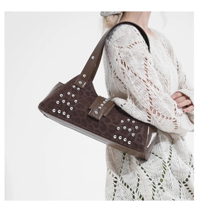 Close-up of leopard print shoulder bag with silver rivet studs and brown leather trim