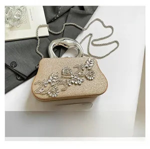 Macro detail of champagne glitter clutch with crystal flower and silver metal handle