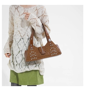 Detail of silver rivets and leopard print texture on a brown suede underarm bag
