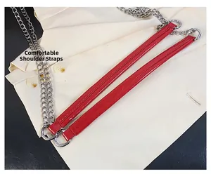 Détail de la bandoulière en cuir rouge brillant avec chaîne et boucle en métal argenté