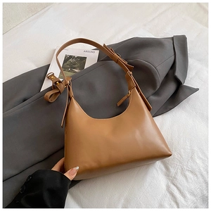 Close-up of caramel leather hobo bag with smooth texture and adjustable shoulder strap