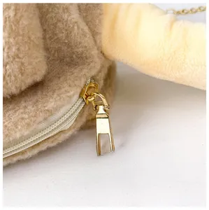 Détail de la fermeture éclair dorée sur le sac bandoulière en polaire sherpa canard