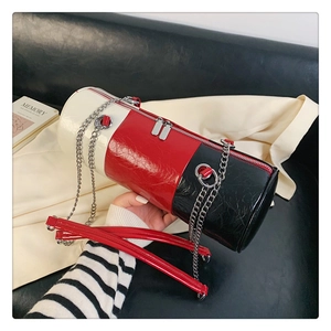 Gros plan d'un sac polochon tricolore en cuir froissé brillant avec bandoulière chaîne