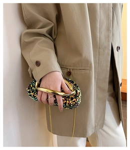 Détail d'un sac de soirée à paillettes colorées avec poignée dorée et fine chaîne