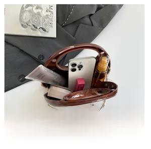 Interior view showing capacity of dark brown tortoiseshell handbag with gold chain