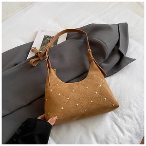 Close-up of brown suede hobo bag with quilted stitching and gold stud details