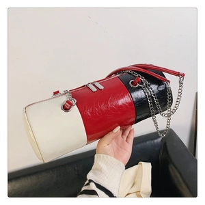 Détails du sac oreiller cylindrique en cuir tricolore avec sa bandoulière en chaîne métal