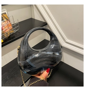 Detail of grey marble acrylic crescent bag with golden chain and round handle