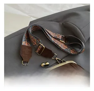 Détail du sac à franges en daim marron avec fermoir en métal et bandoulière tissée