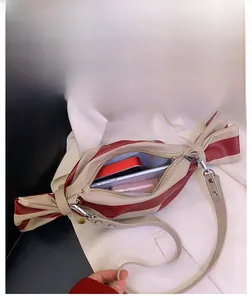 Vue macro montrant la grande capacité interne du sac à bandoulière rayé bonbon
