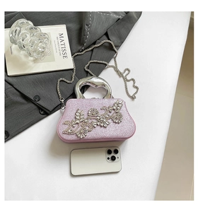 Detailed capacity view of sparkly pink evening bag with rhinestone flowers and silver handle