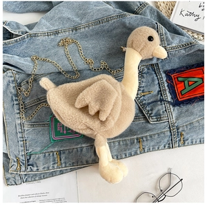 Détail du sac canard en peluche montrant la texture douce et la bandoulière chaîne dorée