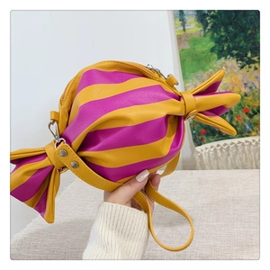 Détail du sac bandoulière en forme de bonbon aux rayures jaunes et violettes et zip