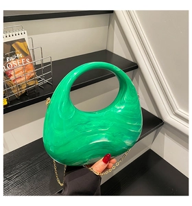 Detail of green marble acrylic half-moon bag with elegant golden chain strap